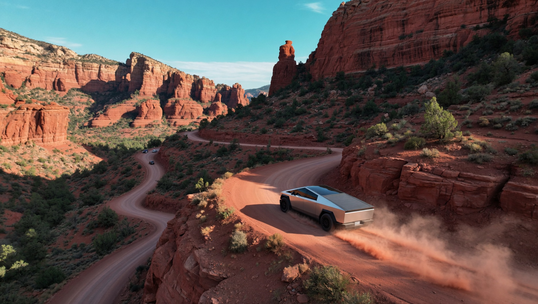Cybertruck on red dirt canyon trail, aerial view